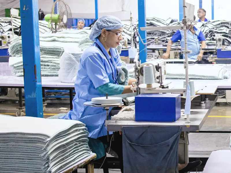 Công nhân dệt may đang may bằng máy trong một xưởng sản xuất nhộn nhịp